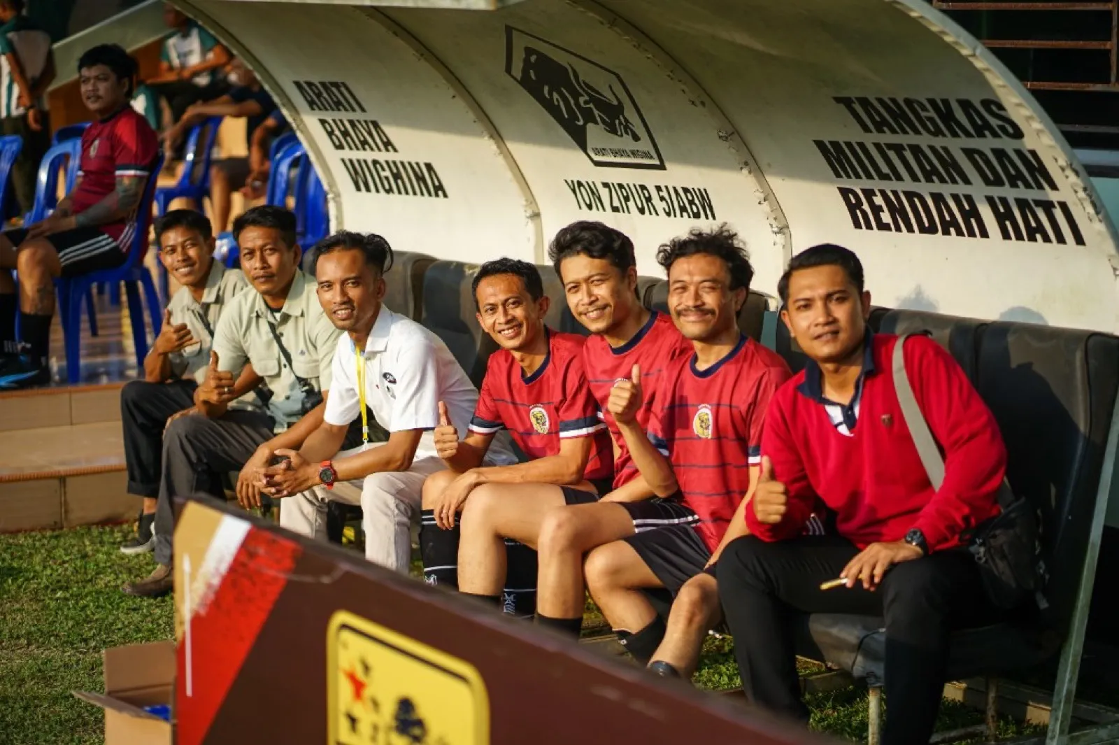 Colleagues on the dugout bench at a sports event